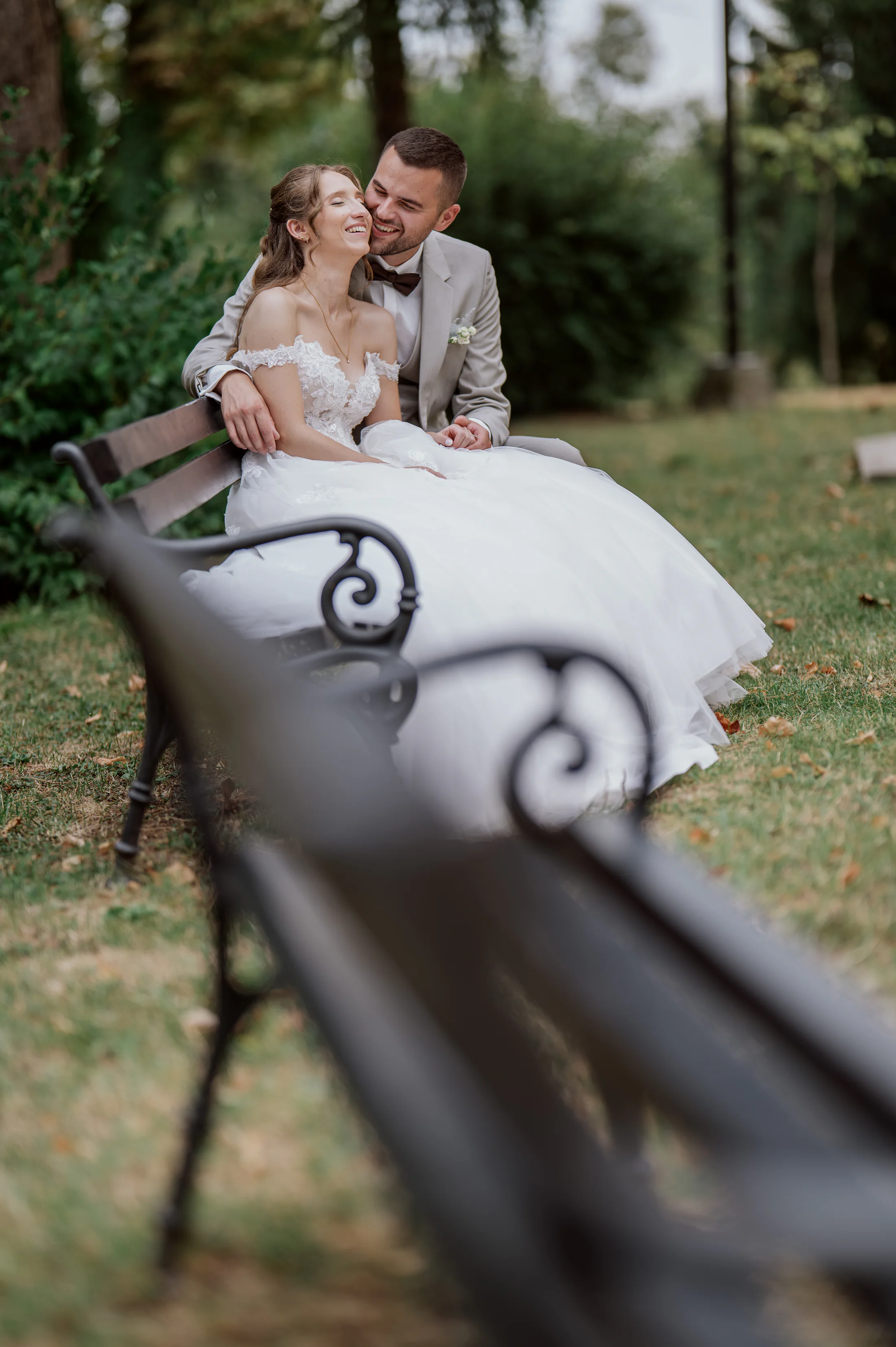 Bride and groom sitting together on a park bench